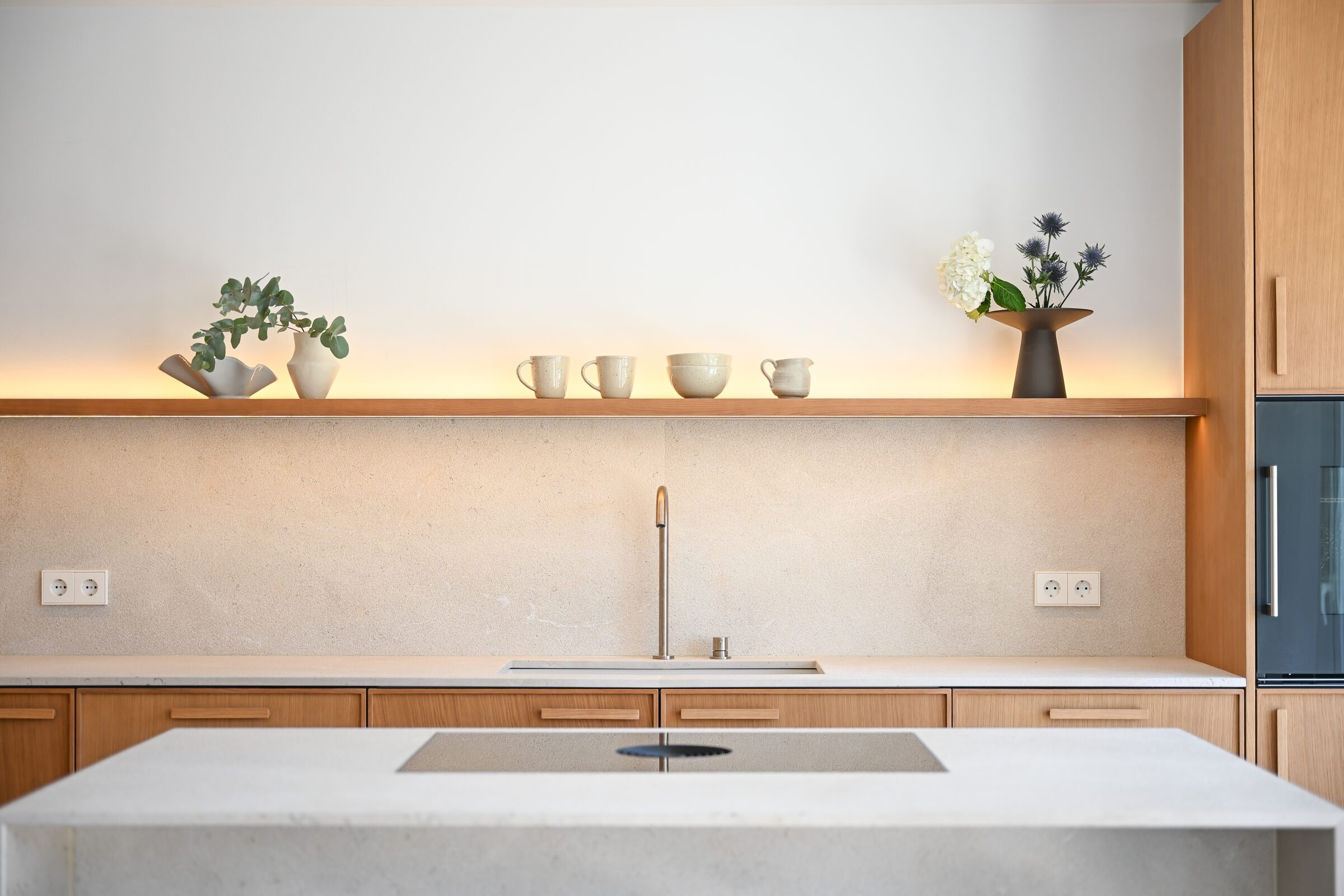 Bathroom with rain shower, brushed-bronze Hansgrohe fittings and a sculpted Binissalem stone basin.
