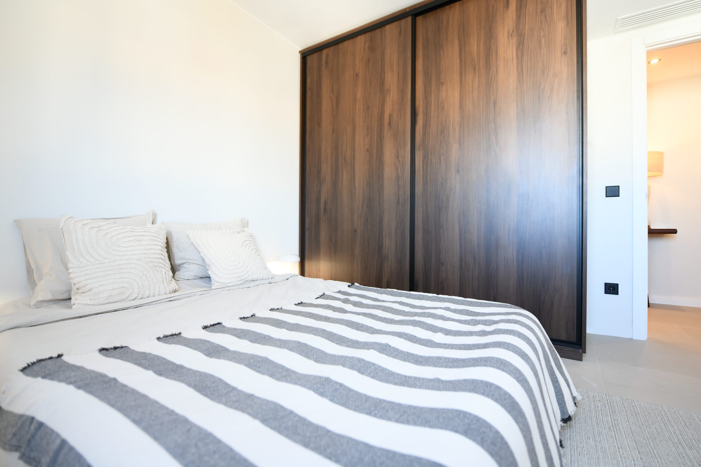 Bedroom featuring a full-height built-in walnut wardrobe.