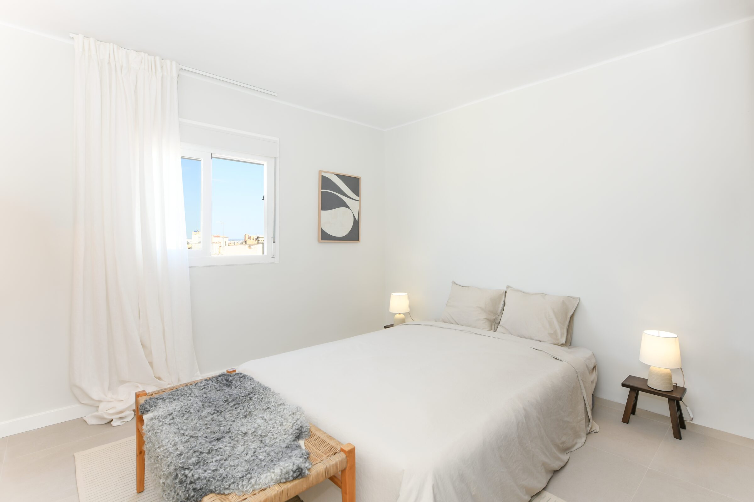 Bedroom detail with layered linen textiles in soft, neutral tones.