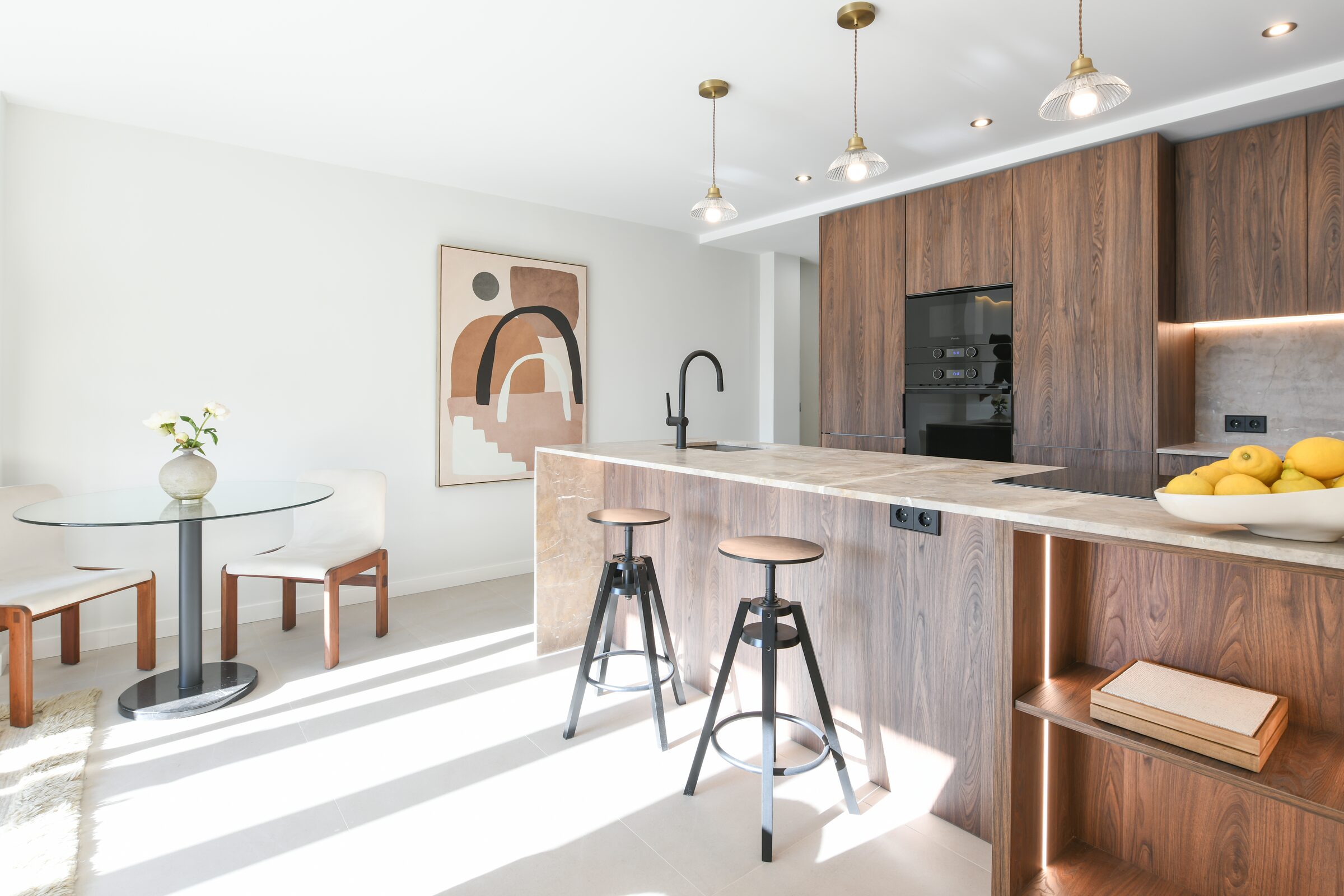 Detail of bespoke walnut cabinetry in the kitchen, paired with natural stone.