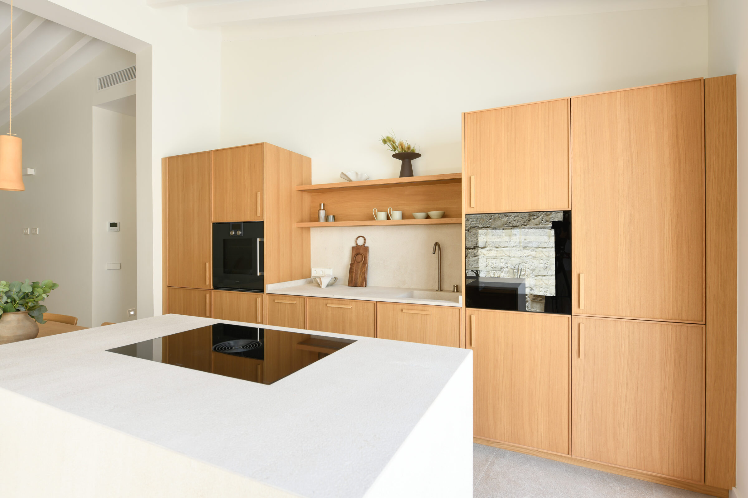 Walnut kitchen with marble island and vaulted ceiling opening to the terrace.