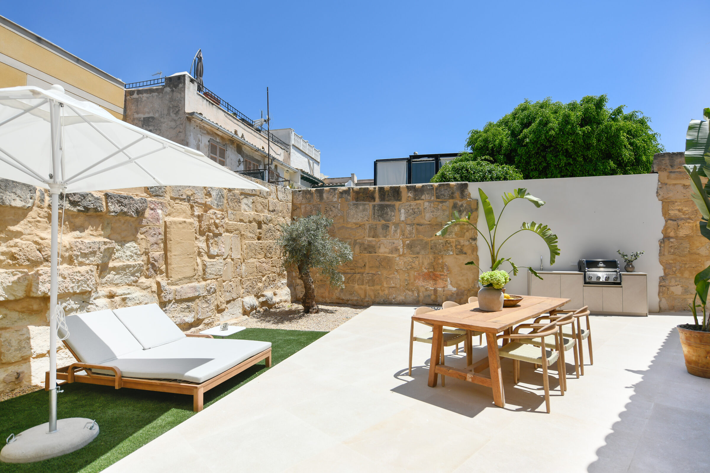 Outdoor dining table, parasol and built-in outdoor kitchen on the Jonquet terrace.