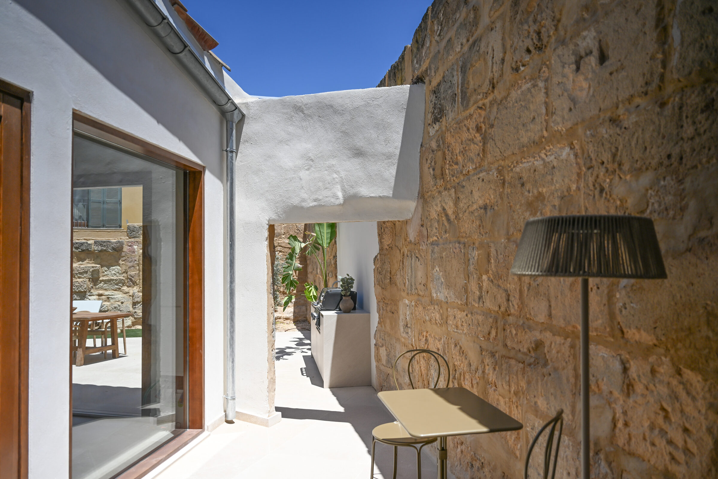 Built-in outdoor kitchen with grill framed by banana plants on the private terrace.