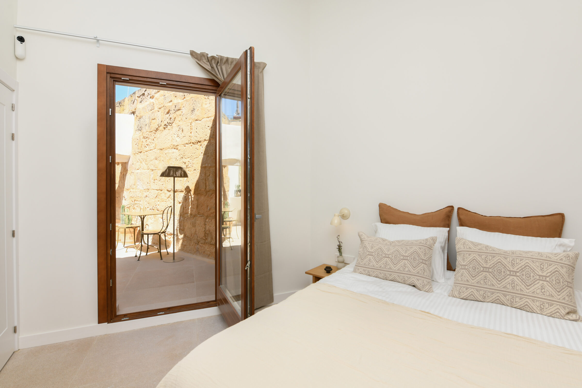 Second bedroom with French doors opening onto the marès stone courtyard.