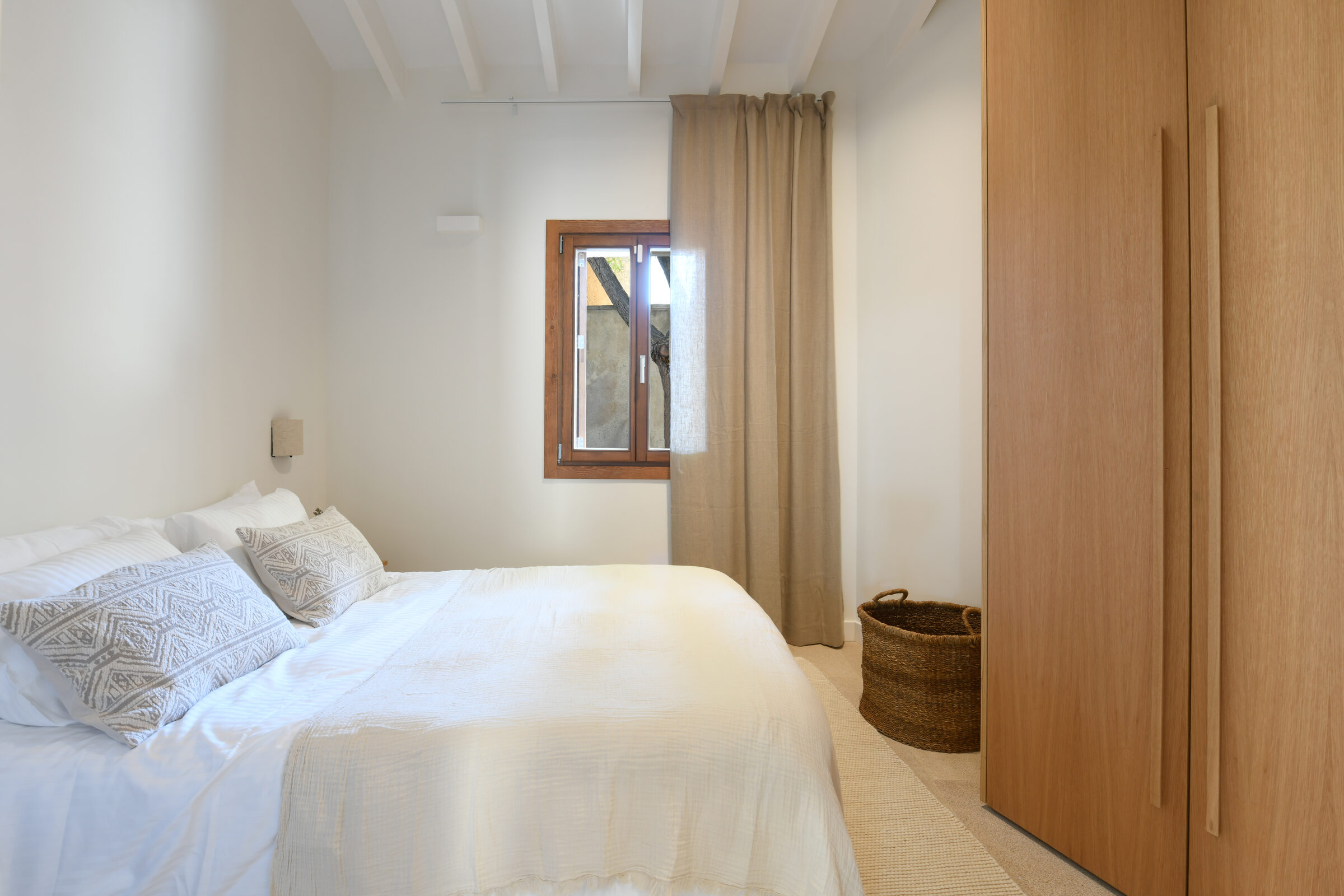 Third bedroom with a walnut wardrobe and garden window framed in oak.