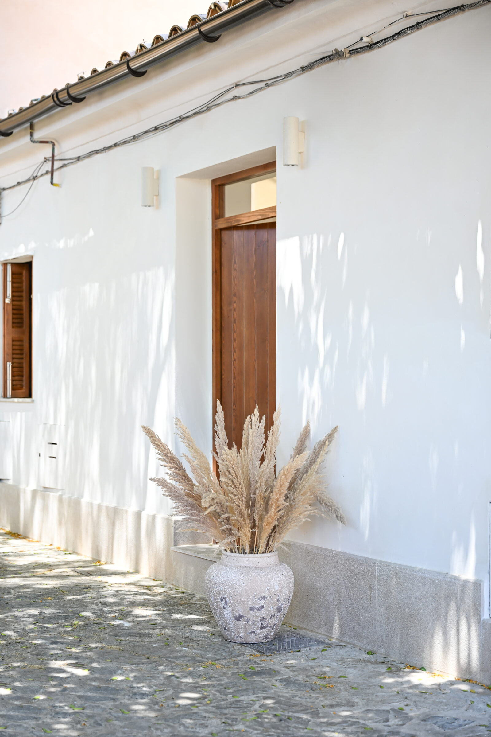 Restored 1887 façade of the Jonquet townhouse with walnut entry door and pampas grass.