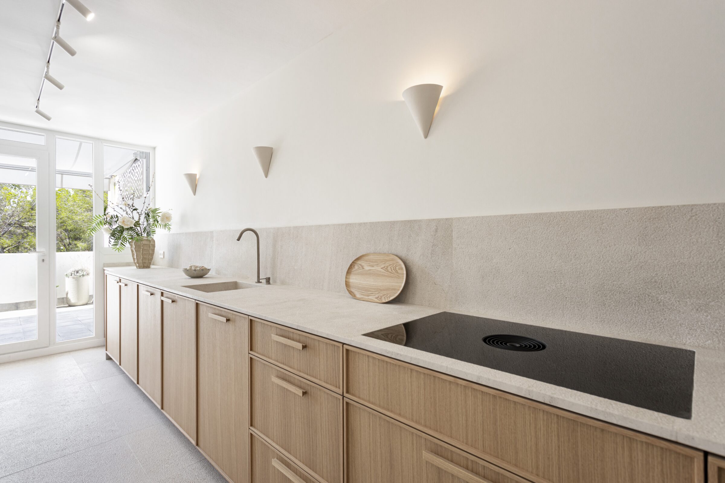 Kitchen with integrated induction hob, Gaggenau appliances and morning light from the terrace doors.